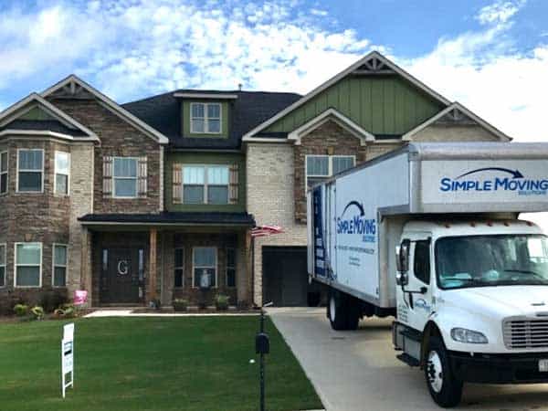 Residential moving truck from Simple Moving LLC parked in front of a house.