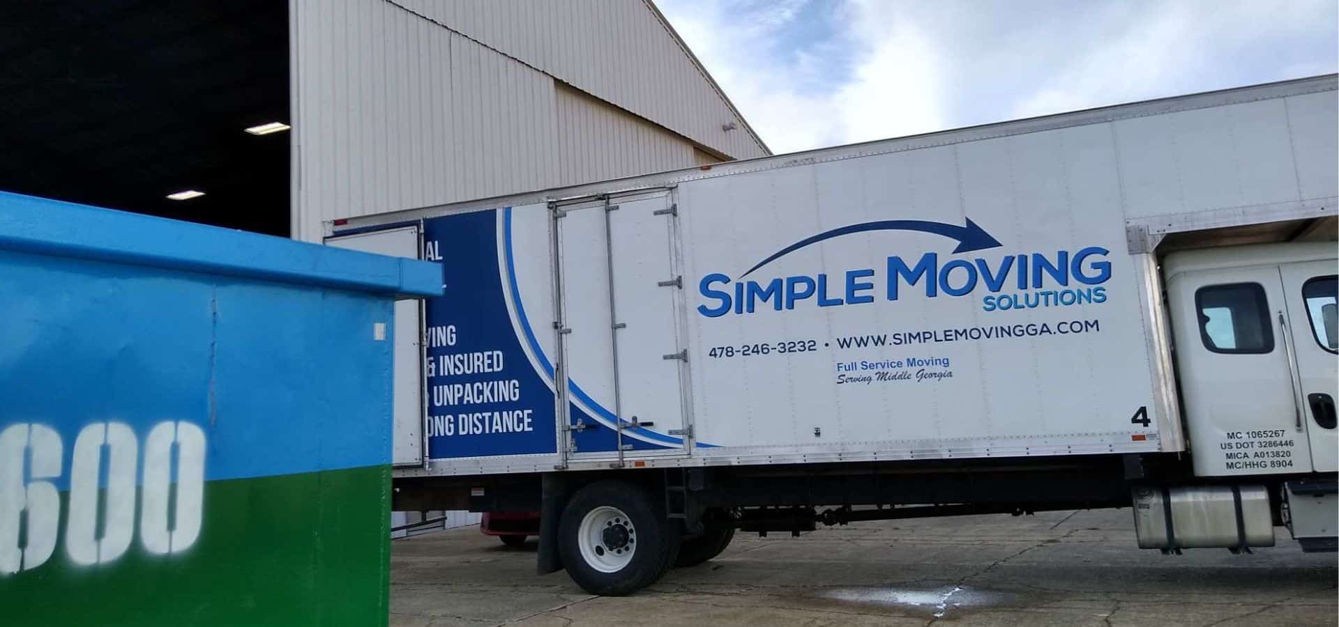 Commercial moving truck parked outside a warehouse for business relocations.