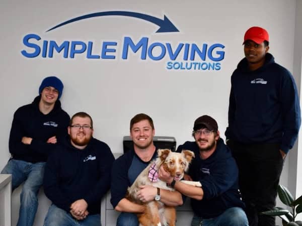Professional moving team with friendly staff and a dog, ready to assist with your relocation needs.